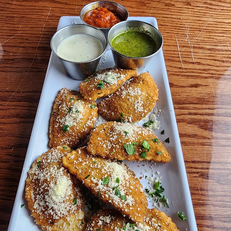 Golden-brown fried ravioli, topped with parmesan and parsley, served with three dipping sauces.